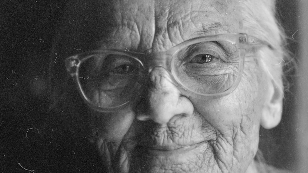 Close up of elderly woman with glasses, black and white